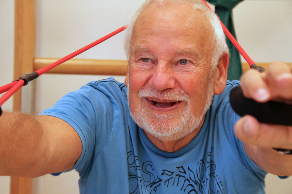 Foto von Dieter Schmidt aus der Ausstellung "Gesichter des Alters": Weißhaariger Mann am Fitnessgerät.